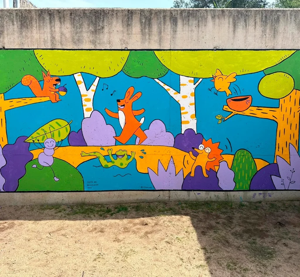 Mural finalitzat amb un conill taronja corrent, una granota verda, un eriçó i ocells, tots en estil naïf, sobre fons blau amb arbres i vegetació en groc, verd i lila